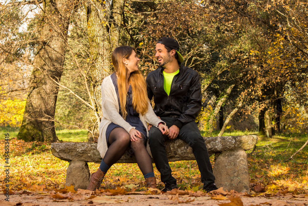 couple sitting on a bench in autumn park