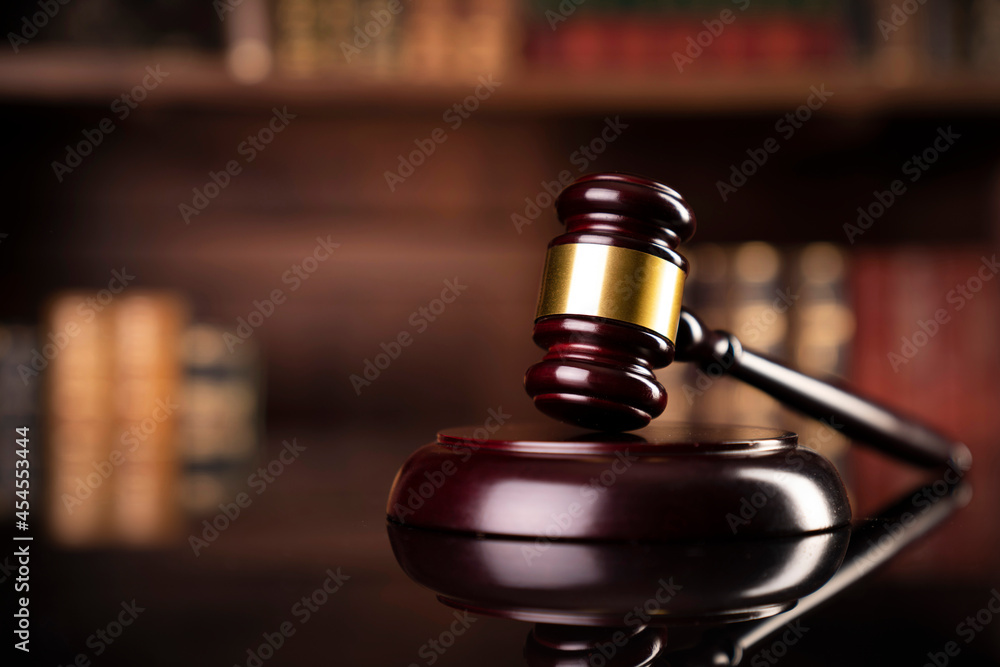 Law theme. Judge chamber. Gavel on brown desk. Collection of legal books in the bookshelf. Law theme. Judge chamber. Gavel on brown desk. Collection of legal books in the bookshelf.