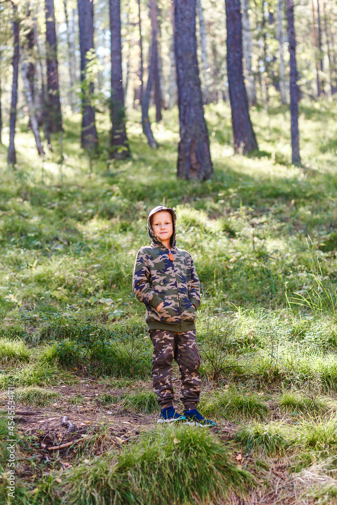 boy in a camouflage suit in the autumn in the woods