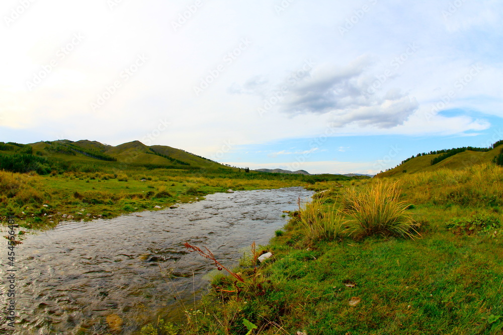 Landscape with a transparent flowing river, where you can see the stone at the bottom in Khakassia