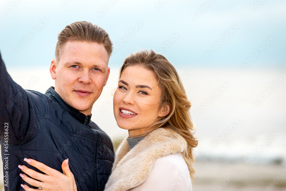 Beautiful young happy woman hugging cuddle young boyfriend while taking selfie photo on sunny beach.Close up. Beautiful young happy woman hugging cuddle young boyfriend while taking selfie photo on sunny beach.Close up.