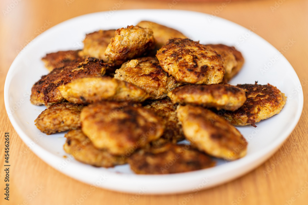 Homemade cutlets,meatballs white plate on a table yellow background.Delicious homemade cutlets.Selective focus. Homemade cutlets,meatballs white plate on a table yellow background.Delicious homemade cutlets.Selective focus.
