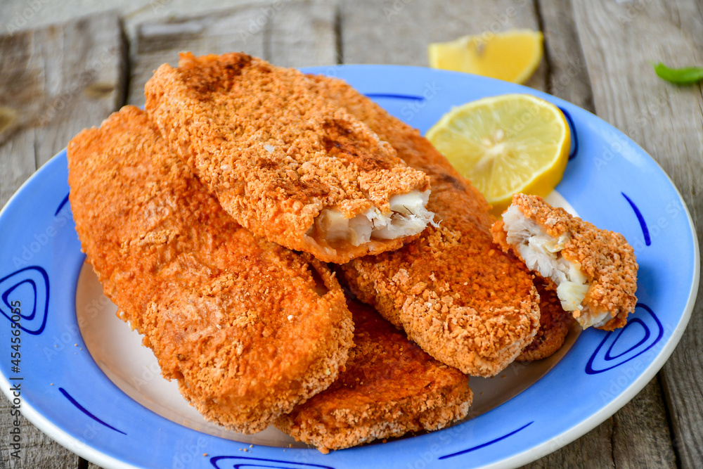 Fish and Chips/Close up of crispy breaded deep fried alaska pollock fillets with breadcrumbs served with remoulade sauce french fries and fresh lemons Fish and Chips/Close up of crispy breaded deep fried alaska pollock fillets with breadcrumbs served with remoulade sauce french fries and fresh lemons