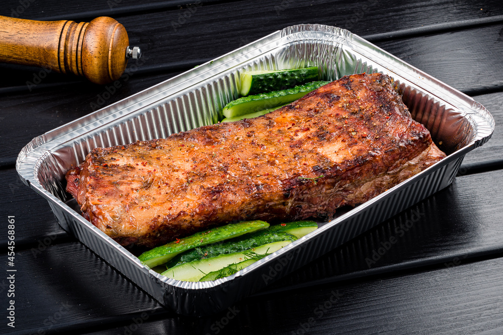 BBQ grilled ribs in a metal tray for delivery. Take out concept, eating at home