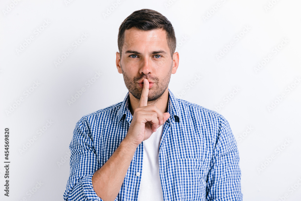 Shh sign. Concerned man holding finger near lips and showing silence ...