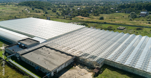 Aerial view over a Greenhouse in Springtime on a Sunny Day. Agriculture and Gardening. Breeding Vegetables in a Glass house. Plant Care.