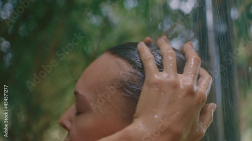 attractive woman in shower wearing bikini washing body cleansing skin with refreshing water enjoying natural beauty spa showering outdoors in nature