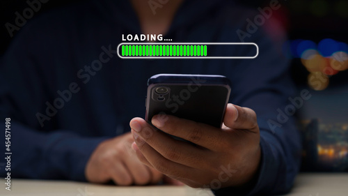 Close up man using mobile smartphone for download application and waiting to loading. loading bar symbol. businessman downloading digital business data form website and cloud to smartphone.