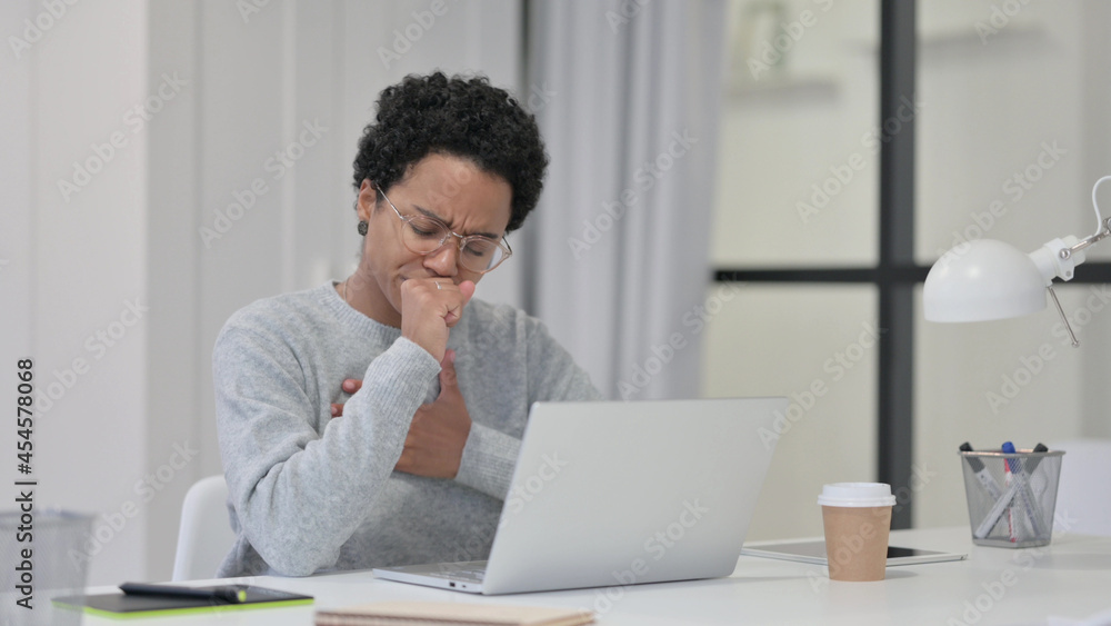 African Woman Coughing while using Laptop at Work African Woman Coughing while using Laptop at Work