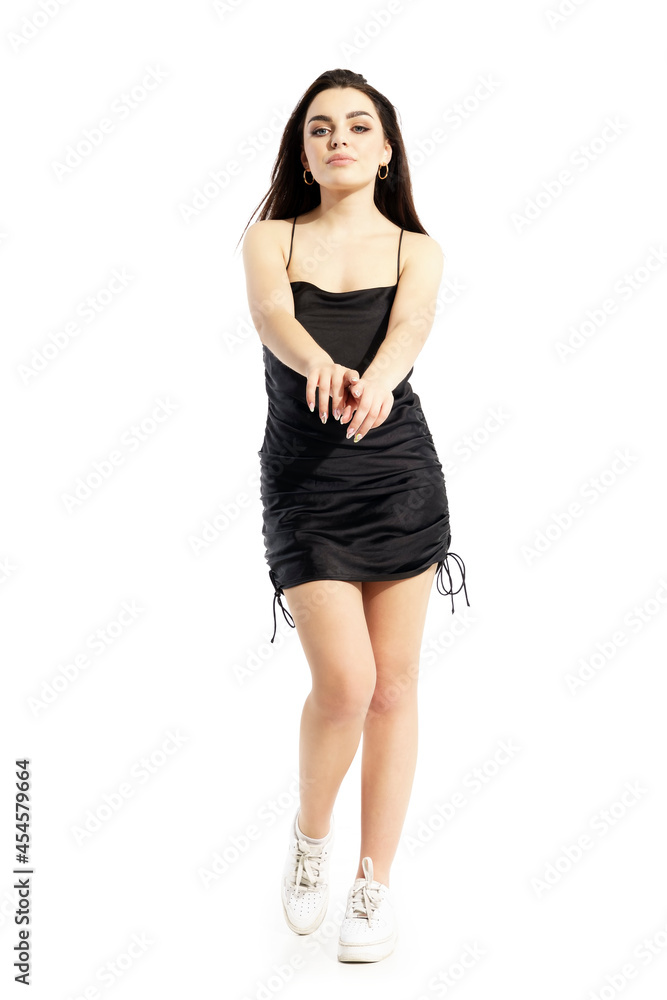 Dancing beautiful young confident black hair woman in black dress. Full body portrait isolated on white background Dancing beautiful young confident black hair woman in black dress. Full body portrait isolated on white background