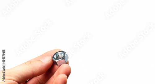 Screw. Metal nut in hand. On white background.