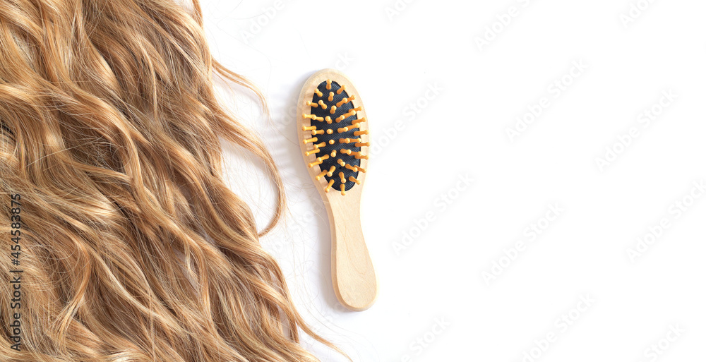 Fototapeta premium Long blond wavy hair and brush isolated on white