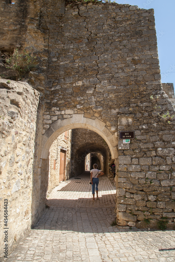 Touriste femme promenant dans une ruelle pavée du village médiéval de Saint-Montan en Ardèche