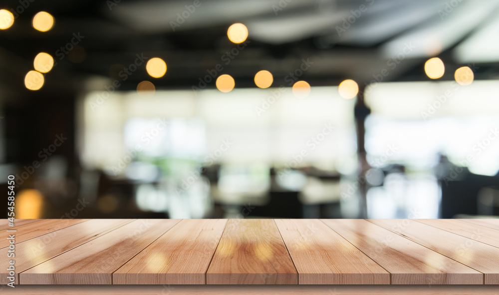 Empty wooden table top with lights bokeh on blur restaurant background.