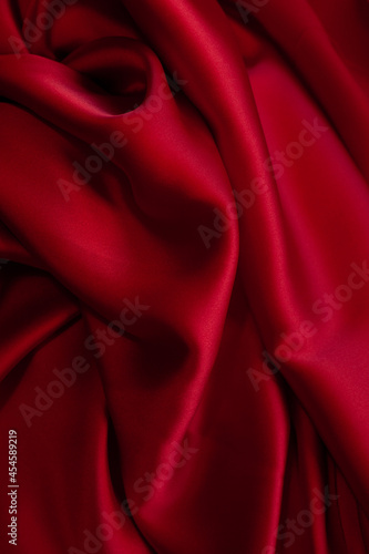 Red fabric texture background. Silk satin folds