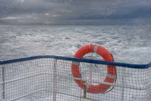 Life buoy on a boat rail in stormy wether and rain.