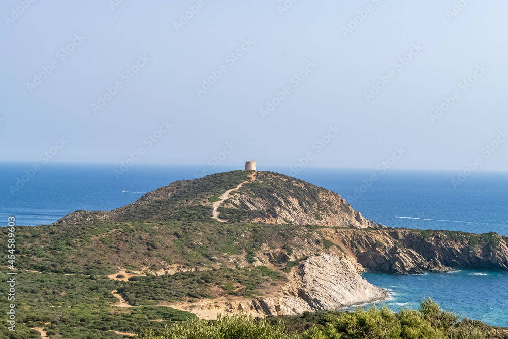 Beautiful view of the southern Sardinian sea. Note the historic Saracen tower on the rock formations.