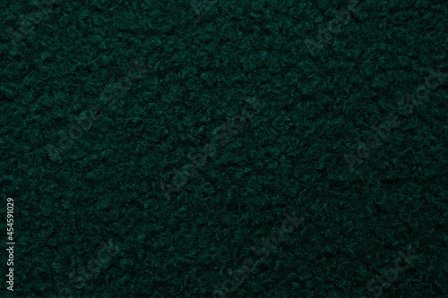 Dark green astrakhan background from warm woolen fabric