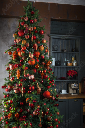 Tall xmas tree stands in a kitchen photo