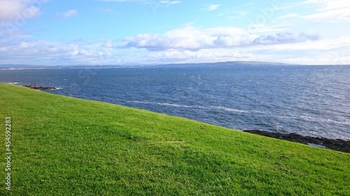 Sunny afternoon on grass lawn with view down on the sea