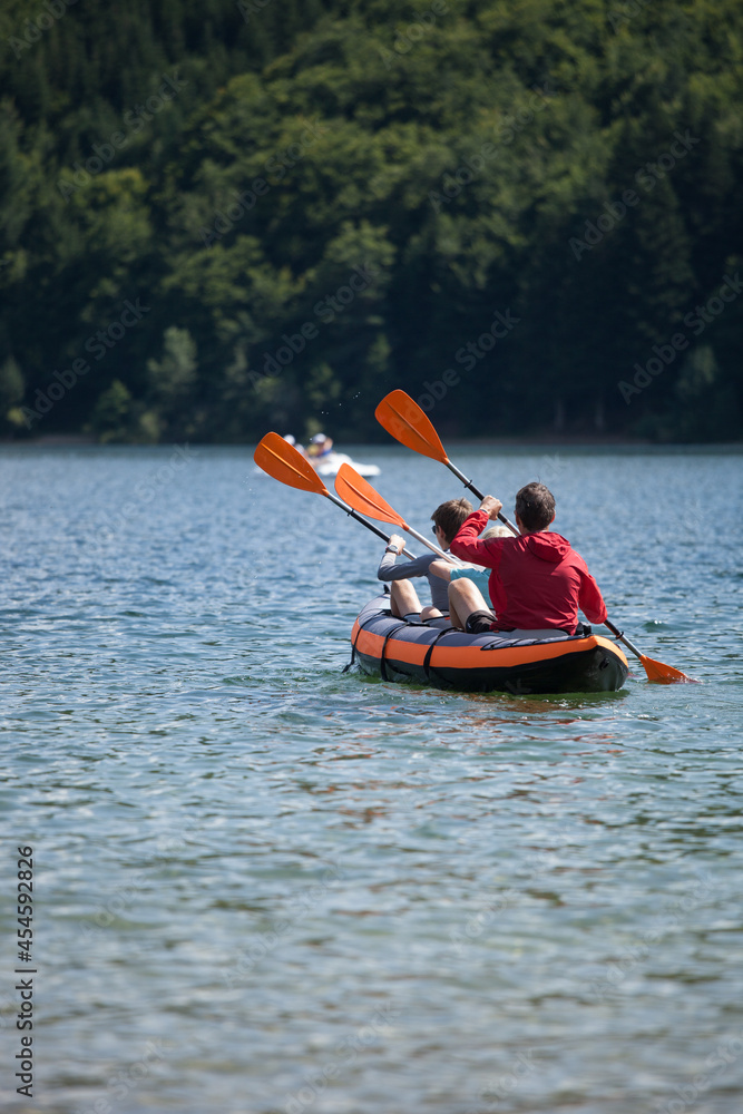 Famille de trois personnes faisant du bateau pneumatique sur le lac d'Issarlès en Ardèche