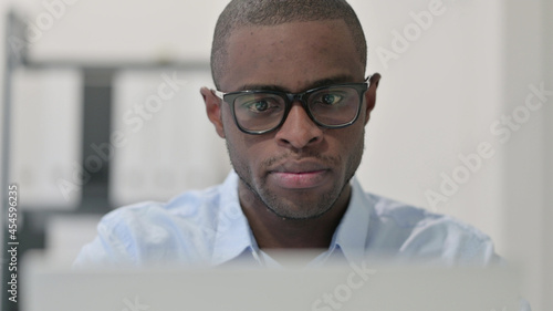 Fototapeta Naklejka Na Ścianę i Meble -  Close Up of African Man using Laptop 