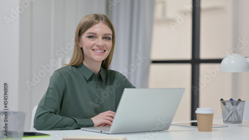Young Woman with Laptop Smiling at Camera 