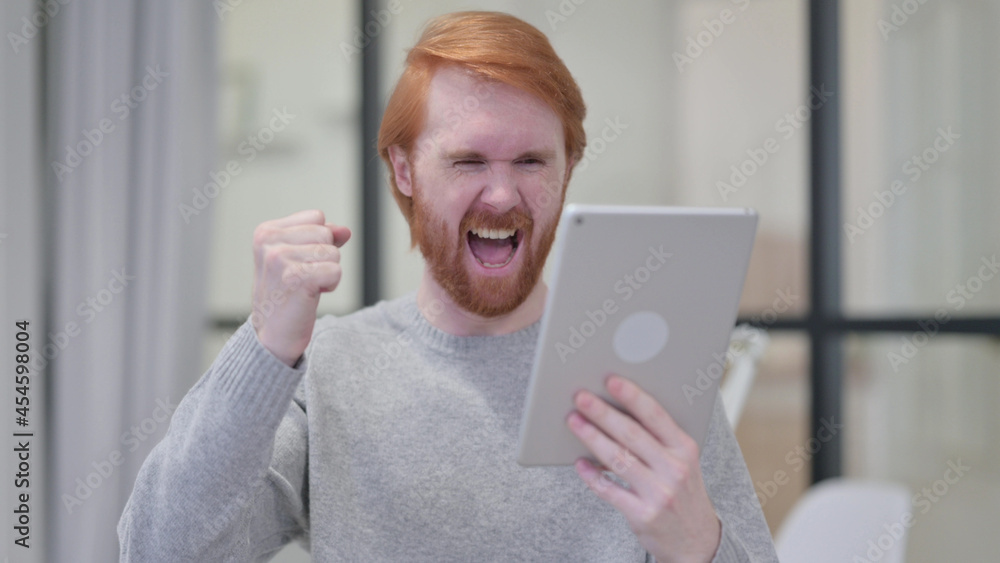 Successful Beard Redhead Man Celebrating on Tablet Successful Beard Redhead Man Celebrating on Tablet