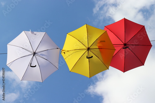 Bunte Regenschirme vor blauem Himmel.