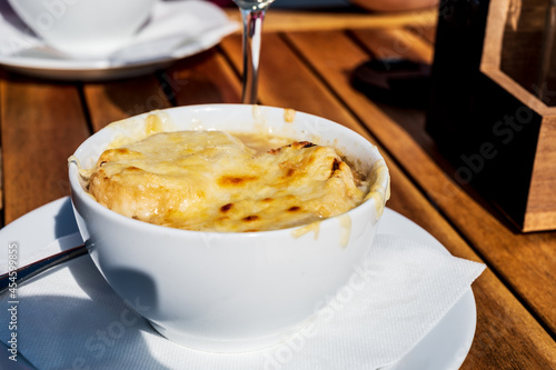 French caramelized onion soup with croutons and gruyere cheesse from oven photo