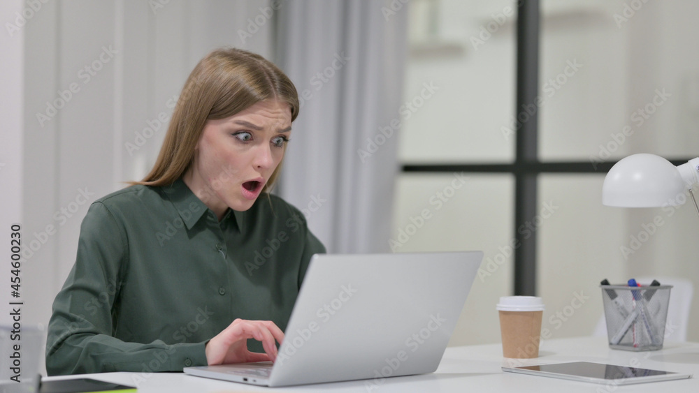 Young Woman Feeling Shocked while using Laptop 