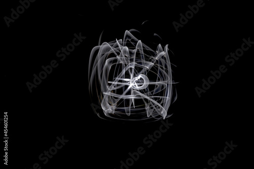 Unique, long exposure, white Led light painting photograph of abstract pattern on black background.