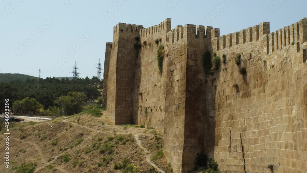 High stone fortress wall of a medieval castle. Journey to the historical sites. The concept of domestic tourism High stone fortress wall of a medieval castle. Journey to the historical sites. The concept of domestic tourism
