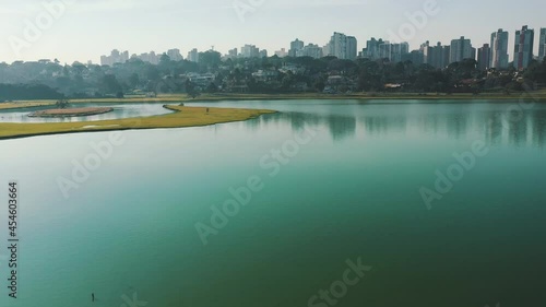 Parque Barigui skyline establishing shot near the water of the lake drone aerial view, Curitiba, Paraná, Brazil	 photo