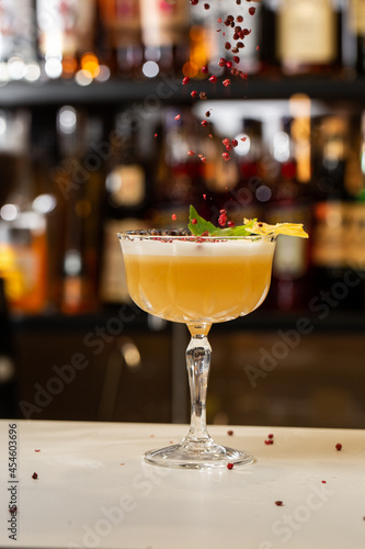 Wallpaper Mural Glass with yellow lemon cocktail decorated with dried pineapple and mint on the blurred bar counter background. Torontodigital.ca