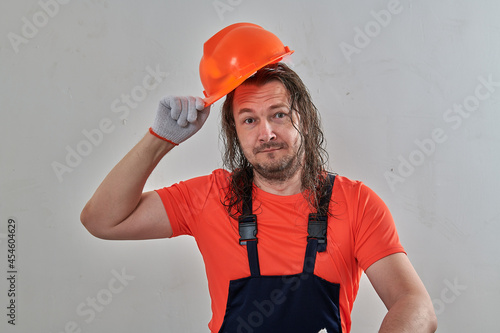 male construction worker takes off his construction helmet