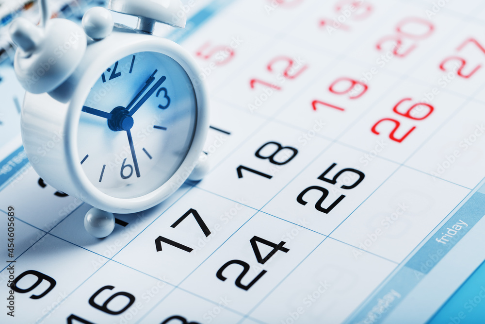 Annual calendar with a white alarm clock on a blue background Annual calendar with a white alarm clock on a blue background