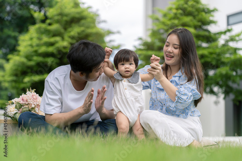 Asian Parents and a kid child playing in the garden at home. Family concept. © Kris Tan
