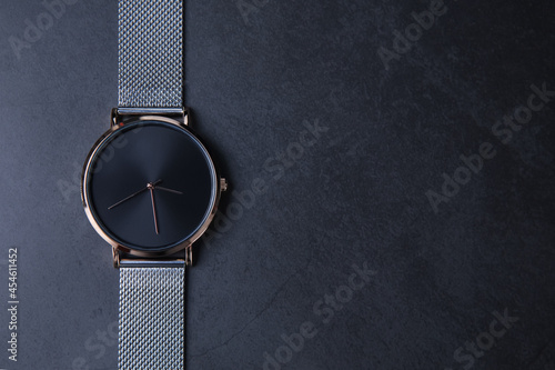 Wrist watch with metal strap for women on gray background