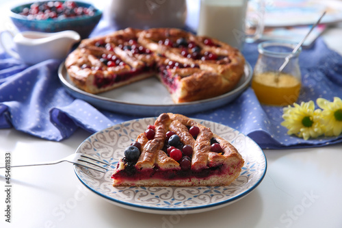 Piece of delicious currant pie with fresh berries served on white table