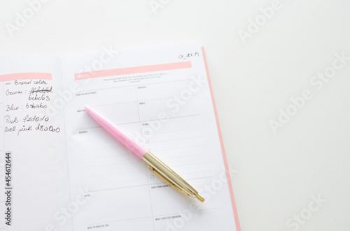 Planner for new years resolutions. Pink planner on a white desk. 