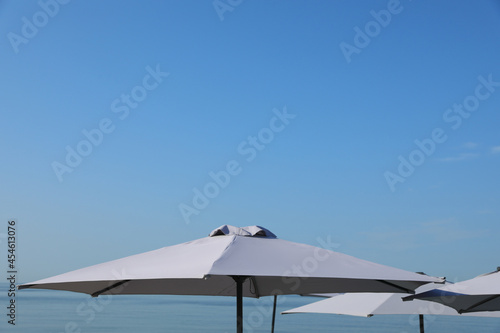 Beach umbrellas against blue sky on sunny day © New Africa