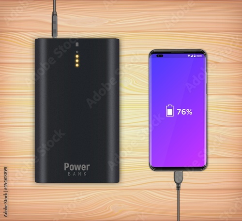 Modern smartphone connected to the black power bank and charge.