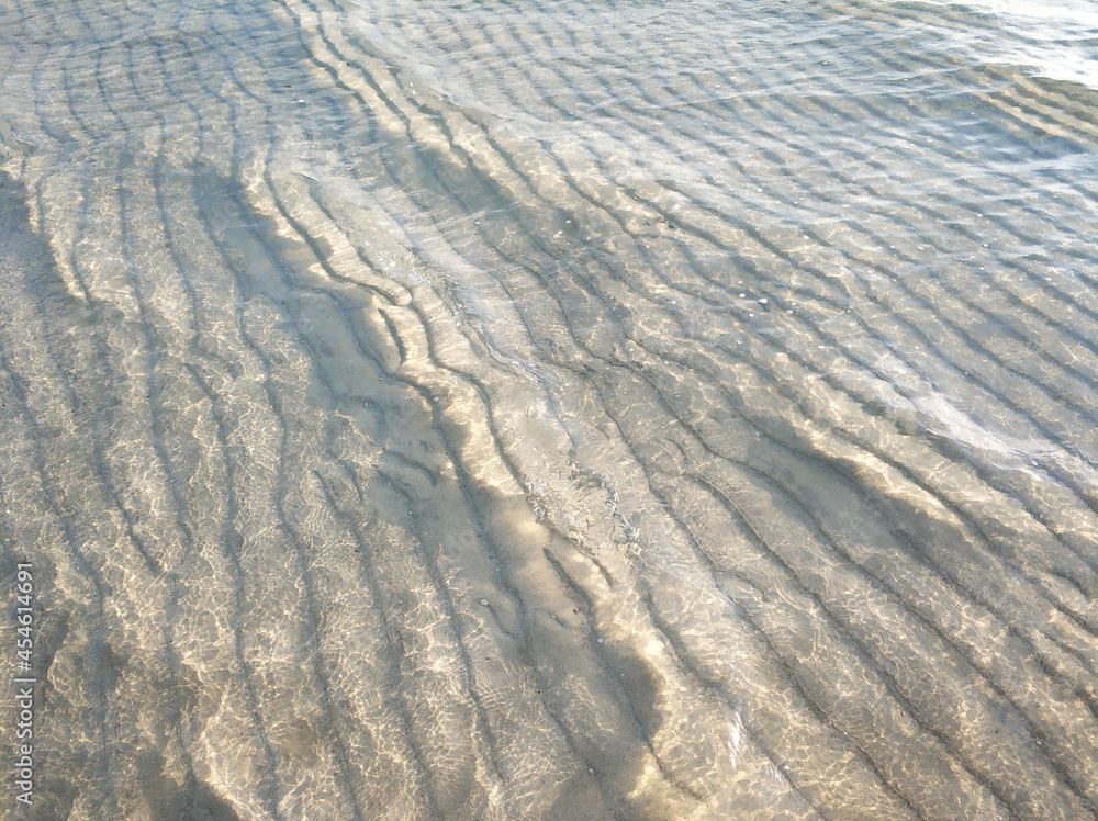 Wavy surface of the sandy ocean floor near the shore at low tide Wavy surface of the sandy ocean floor near the shore at low tide