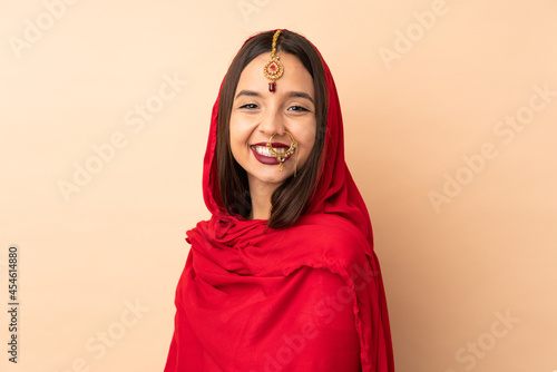 Young Indian woman isolated on beige background © luismolinero
