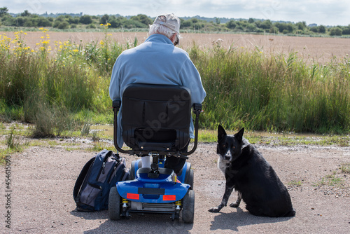 Collie dog sits by his elderly owner.