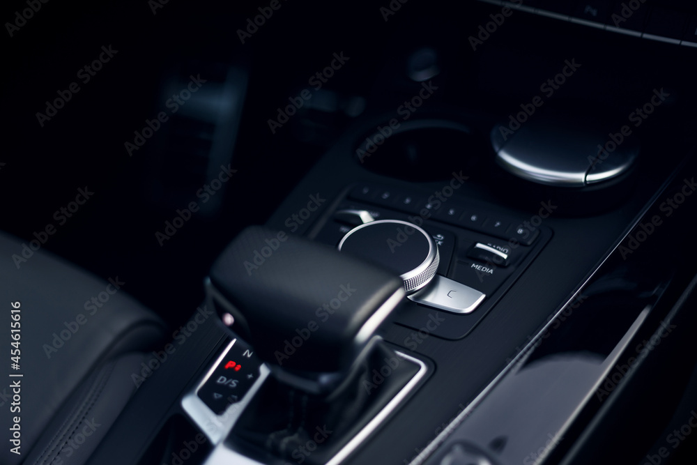 Naklejka premium Car options selection button. Leather car interior. Modern car illuminated dashboard. Luxurious car instrument cluster. Close up shot of automobile instrument panel. Modern car interior dashboard