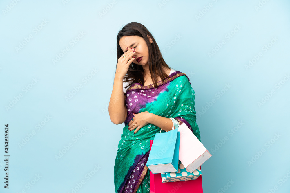 Young Indian woman with shopping bags with headache Young Indian woman with shopping bags with headache