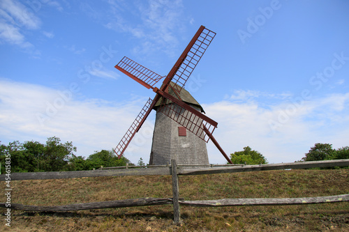 tall old gray windmill with spinning arms