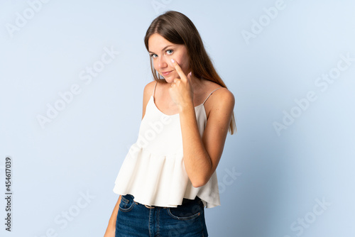Young Lithuanian woman isolated on blue background showing something